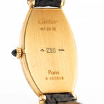 Nahaufnahme einer Vintage Cartier Tonneau 18k Guilloché Paris aus den 1980er Jahren. 39 mm mit Gehäuse aus 18k Gelbgold, Uhrwerk mit Handaufzug, Original Guilloché Paris Zifferblatt und schwarzem Lederarmband.
