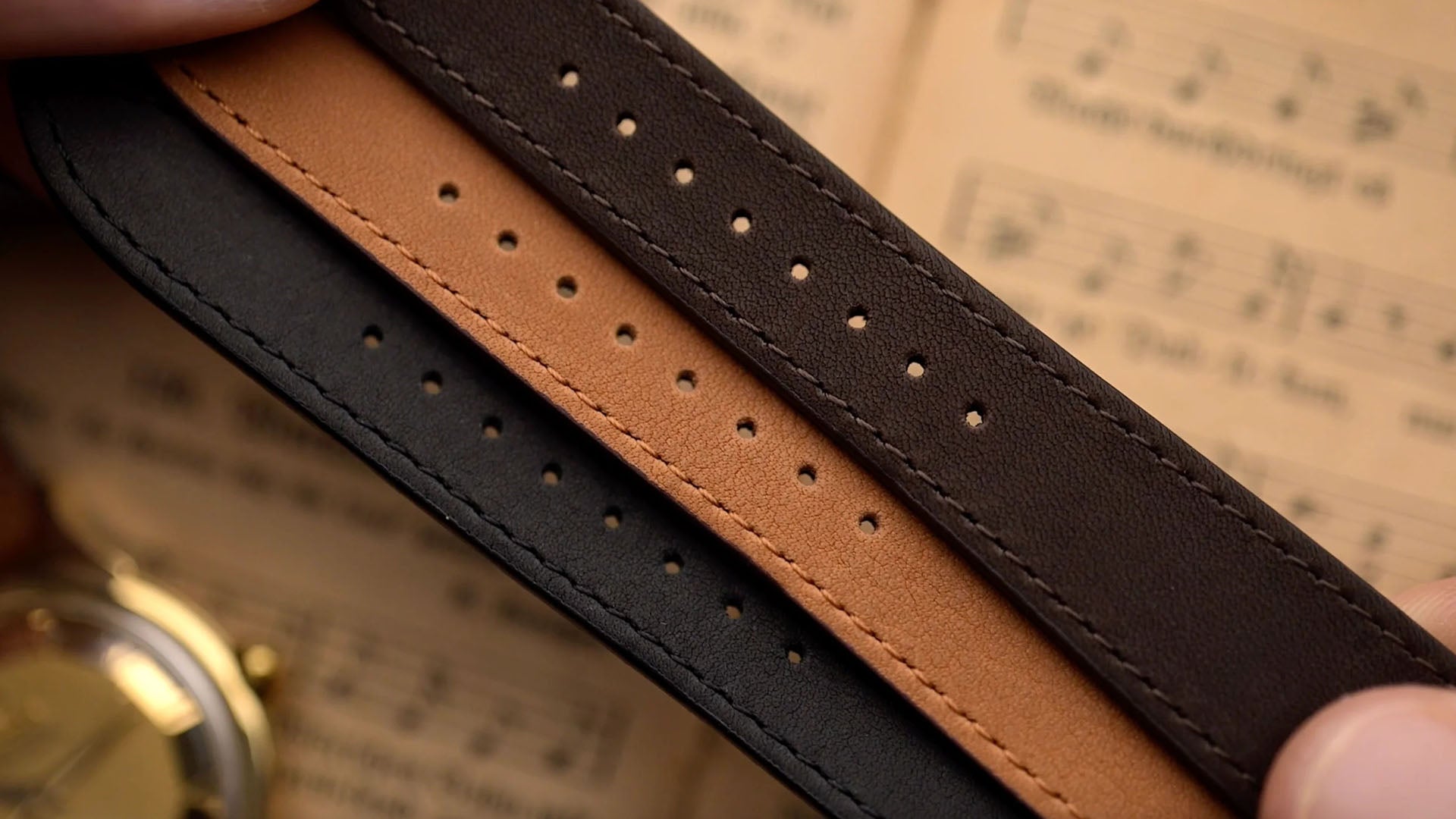 Schwarze, braune und cognacfarbene Lederarmbänder mit gestanzten Löchern.