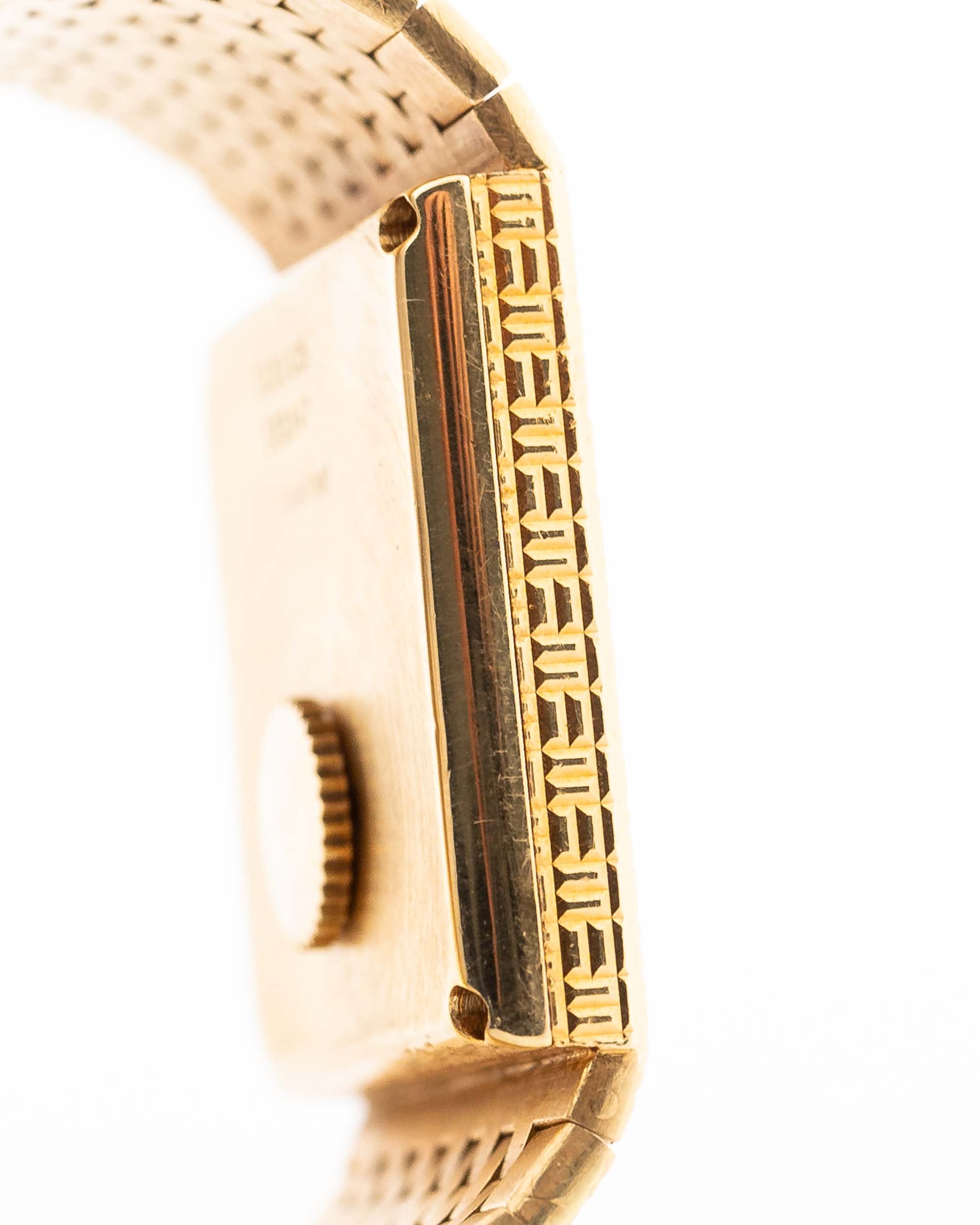 Nahaufnahme des Gehäuses der Vintage Piaget Polo 7131 C5. 23 mm aus 18k Gelbgold mit guillochiertem Zifferblatt, integriertem 18k Goldarmband und Quarzwerk.