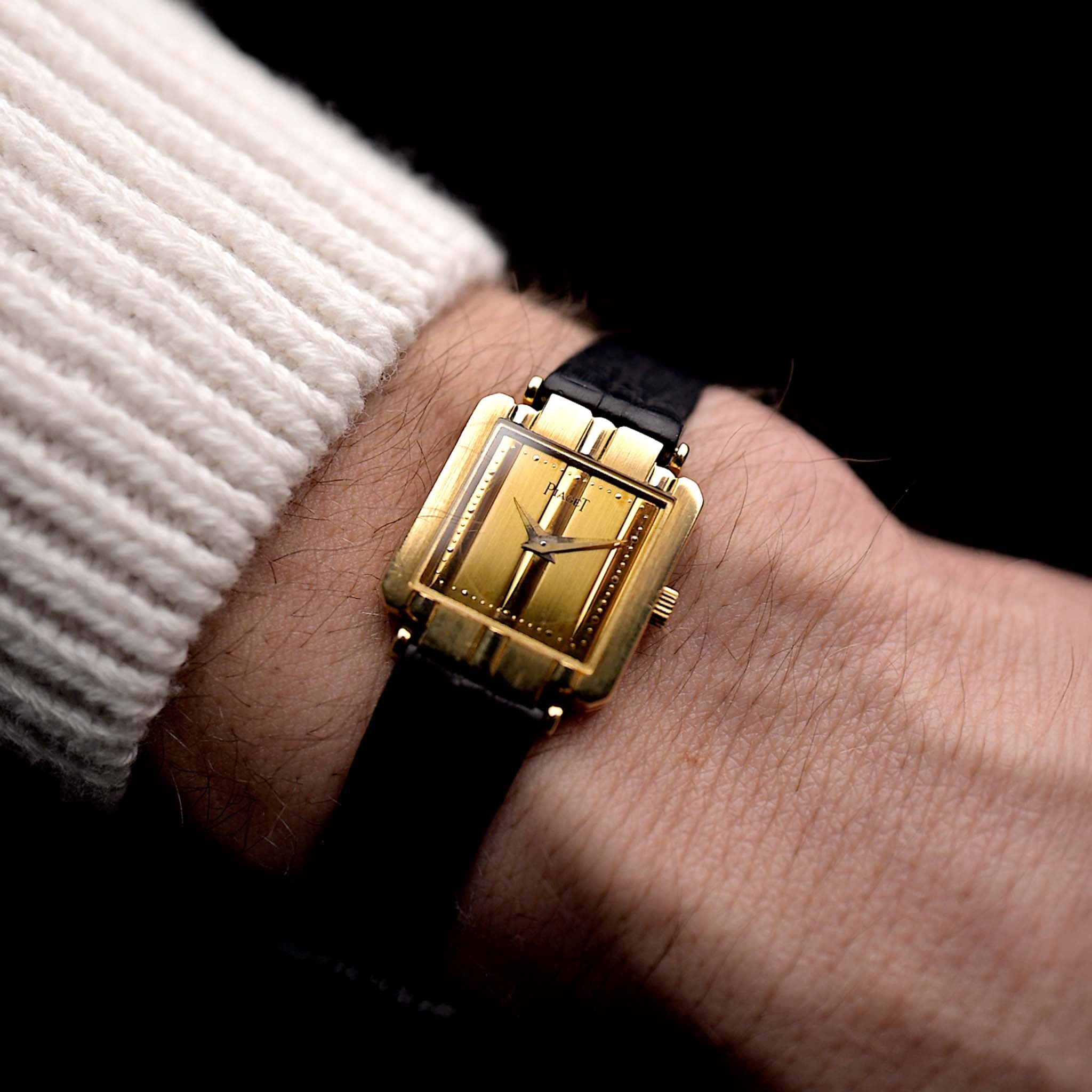 Foto einer Vintage Piaget Polo 8193 Rectangular aus den 1980er Jahren an einem Handgelenk. In 18k Gelbgold, 20mm mit Quarzwerk, originalem goldenem Zifferblatt, originalem Lederarmband und 18k Goldschließe.