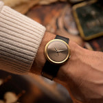 Vintage Rolex Precision 9919 Uhr, 18 Karat Gold, graues Zifferblatt, Gehäuseform Disco Volante, an einem Handgelenk, unscharfer Hintergrund