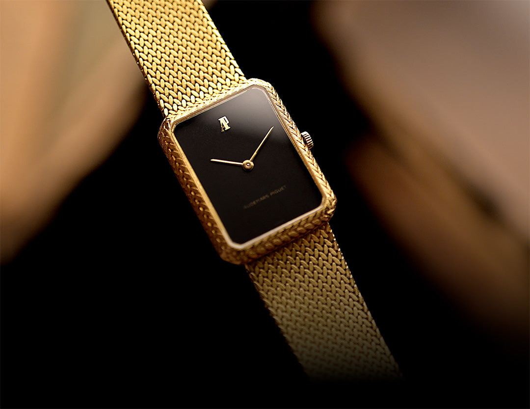 Vintage Uhr Audemars Piguet mit goldenem Armband und schwarzem Zifferblatt.