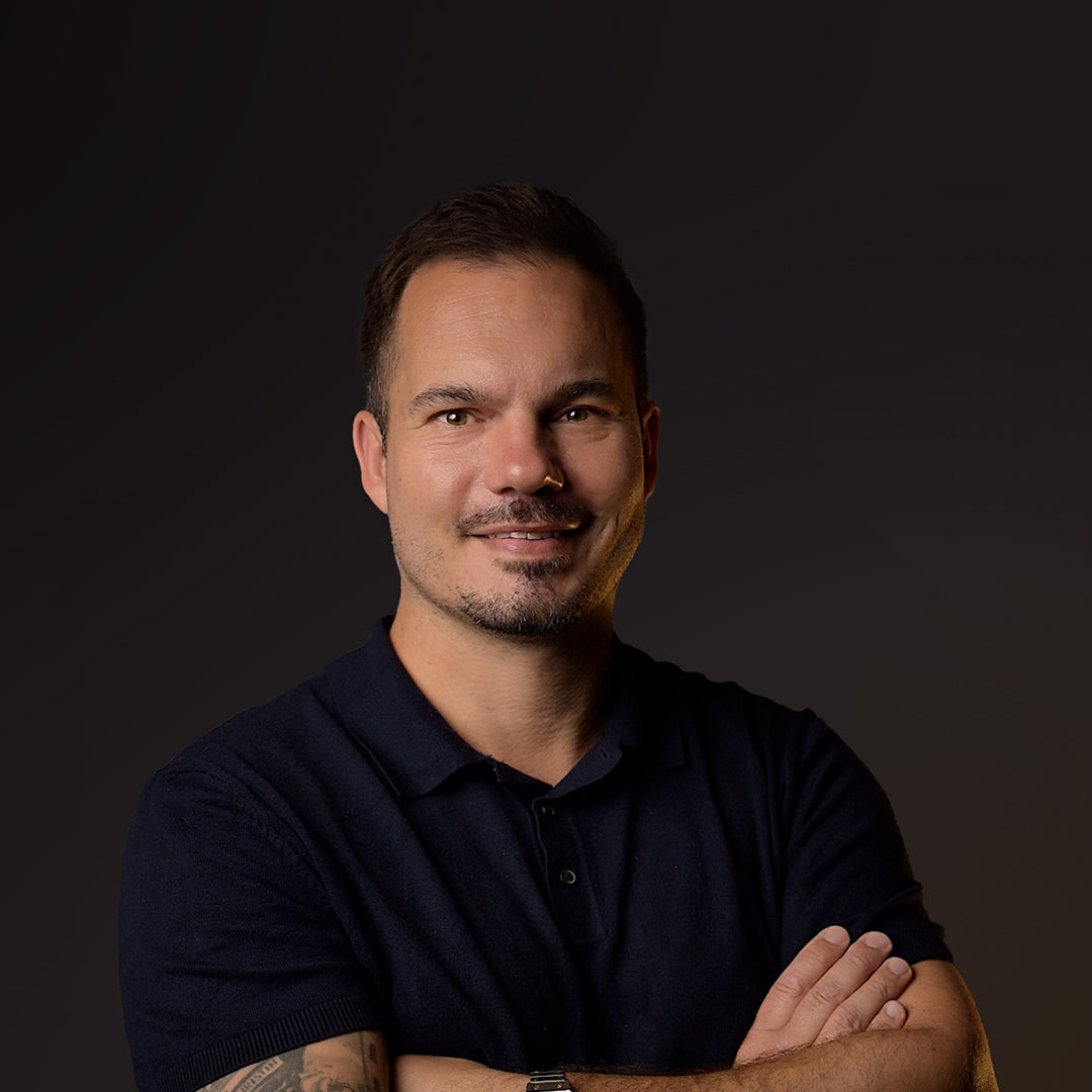 Mann mit dunklem Poloshirt vor dunklem Hintergrund