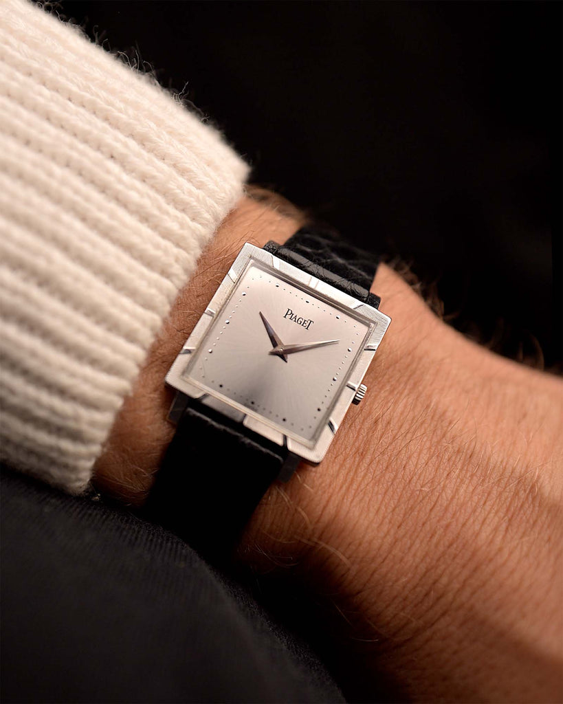 Vintage Piaget Protocole 927 Uhr 18k Weißgold aus den 1970er Jahren an einem Handgelenk. 25 mm aus 18 Karat Weißgold mit Handaufzug, originales silberfarbenes Zifferblatt mit Sonnenschliff, originales schwarzes Lederarmband, Dornschließe aus 18 Karat Weißgold.