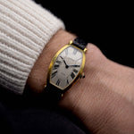 Video von einer Vintage Cartier Tonneau 18k Guilloché Paris aus den 1980er Jahren an einem Handgelenk. 39mm mit Gehäuse aus 18k Gelbgold, Uhrwerk mit Handaufzug, Original Guilloché Paris Zifferblatt und schwarzem Lederarmband.