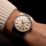 Vintage Rolex Datejust 1603 Uhr von 1972, 36mm Edelstahlgehäuse, silbernes Sonnenschliff-Zifferblatt, Jubilee-Armband am Handgelenk einer Person mit dunklem Hintergrund, Video