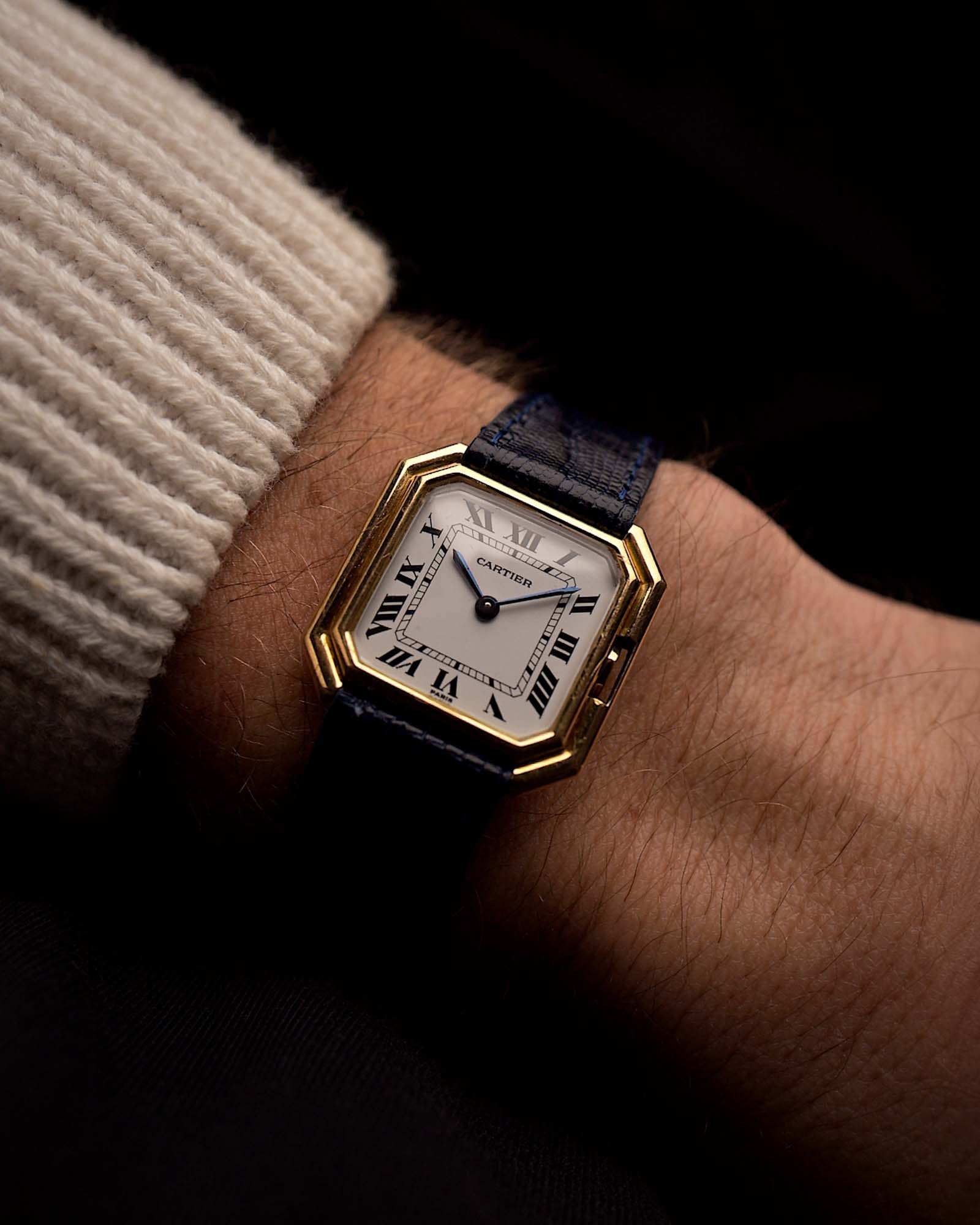 Vintage Cartier Ceinture 78099 Uhr mit quadratischem Gehäuse aus 18 Karat Gelbgold, weißem Zifferblatt, Handaufzug und blauem Lederarmband auf schwarzem Hintergrund. Video verfügbar.