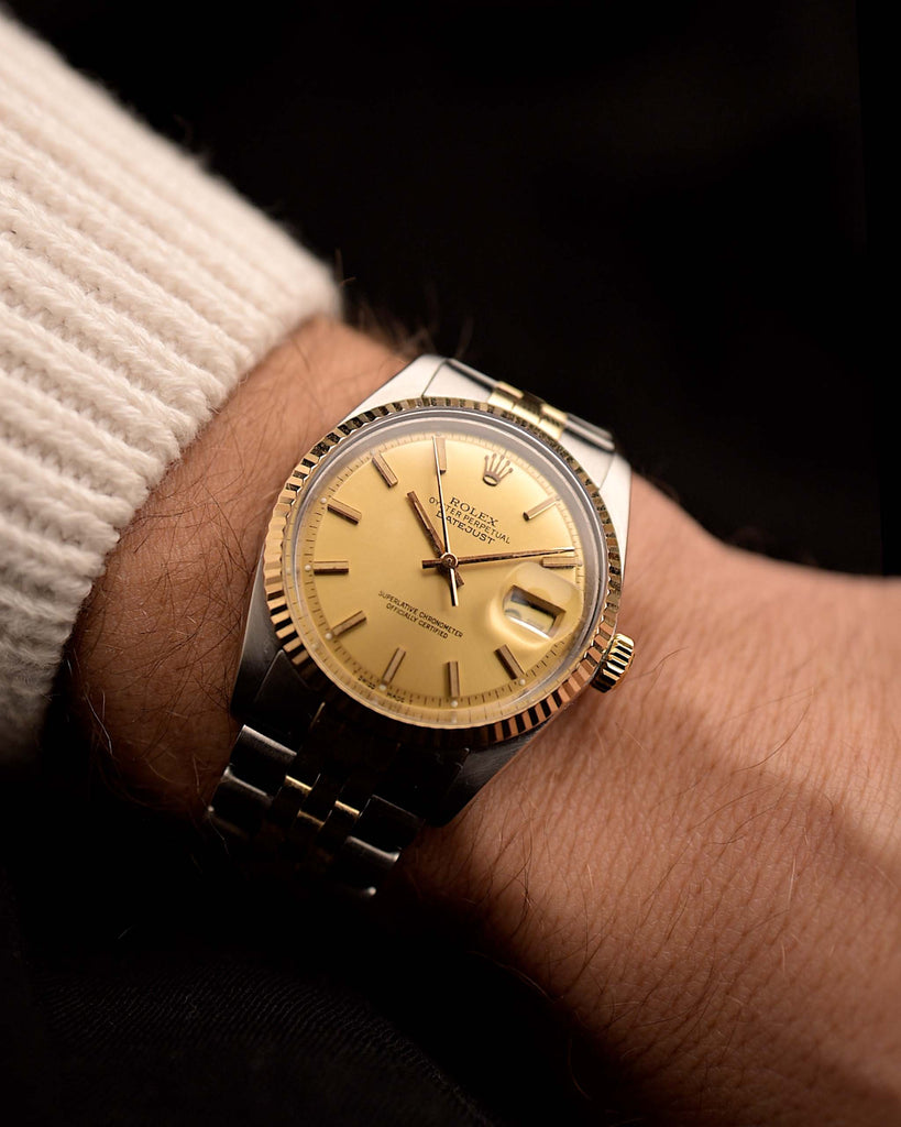 Rolex Datejust 1601 Two Tone from 1970 on a wrist on black background. 36mm wide in Two-tone gold/stainless steel with Rolex Caliber 1570, Flawless gold pie pan dial and Two-tone Jubilee bracelet.