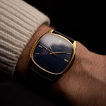 Vintage Patek Philippe 3585 Uhr aus 18 Karat Gold, Kissenform, blaues Zifferblatt, Cal. 350, schwarzes Alligatorlederarmband an einem Handgelenk vor schwarzem Hintergrund, Video