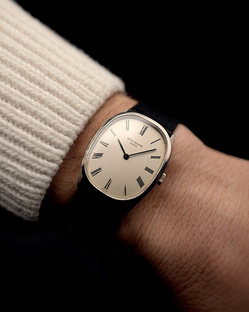 Vintage Patek Philippe Ellipse Uhr 3546 Roman 18k aus den 1970er Jahren an einem Handgelenk. 27mm × 34mm mit Gehäuse aus 18k Weißgold, originalem silbernen Zifferblatt, Handaufzugskaliber 23-300 und Lederarmband.