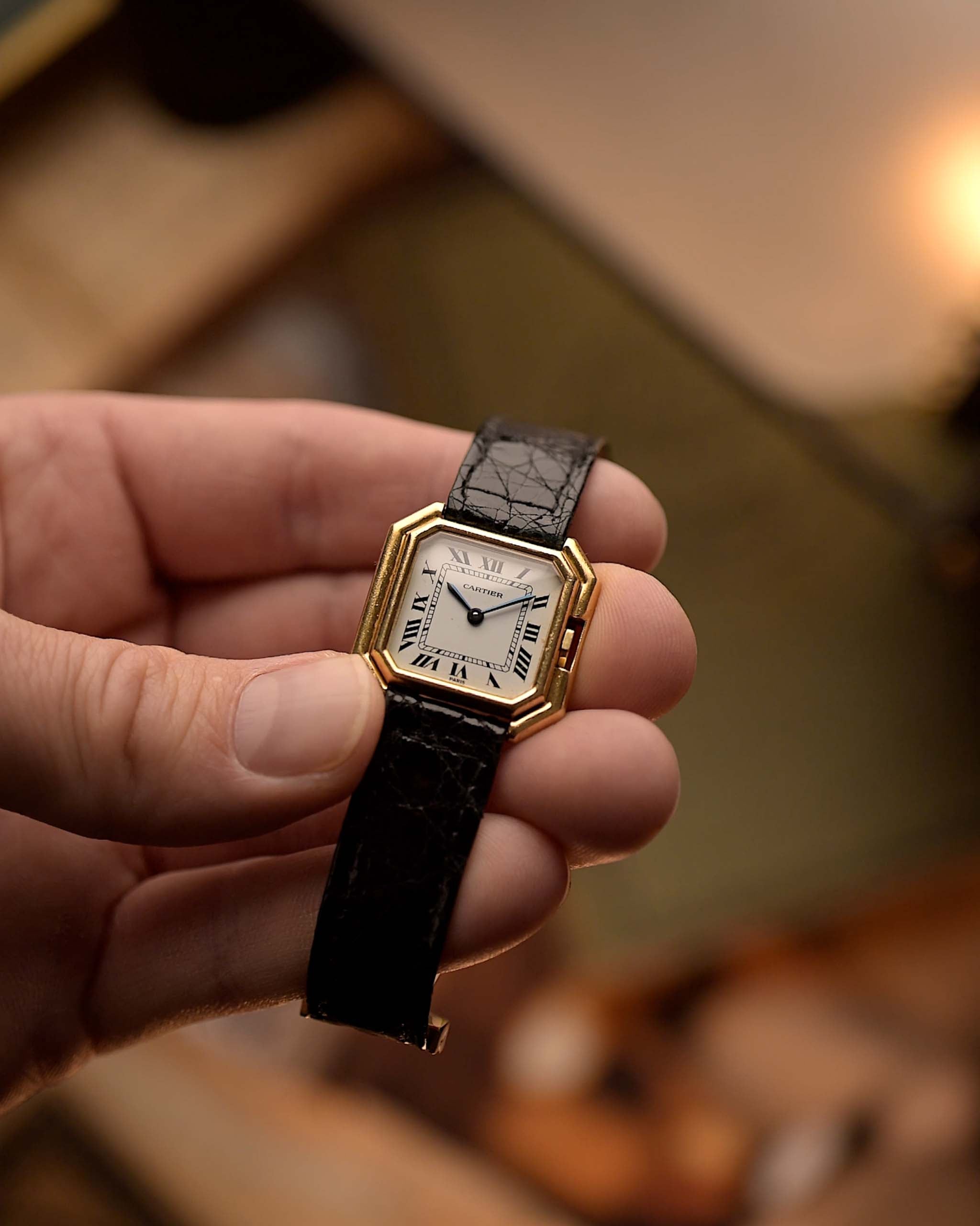 Reloj Cartier Ceinture 78210 vintage de oro amarillo de 18 quilates, esfera MK3 blanca, cuerda manual, en la mano, fondo borroso