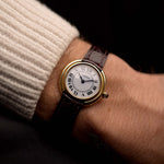 Reloj vintage Cartier Ellipse de oro de 18 quilates, esfera blanca firma París, correa original de cuero rojo, en la muñeca, fondo negro