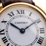 Primer plano de un reloj Cartier Vintage Ellipse de oro de 18 quilates, esfera blanca con la firma de París. fondo blanco