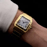 Foto de un Cartier Santos Carrée 2964 de los años 80 en muñeca. En Excelente estado, caja de 27mm en Oro Amarillo con movimiento Automático, esfera blanca Original y brazalete de Oro.