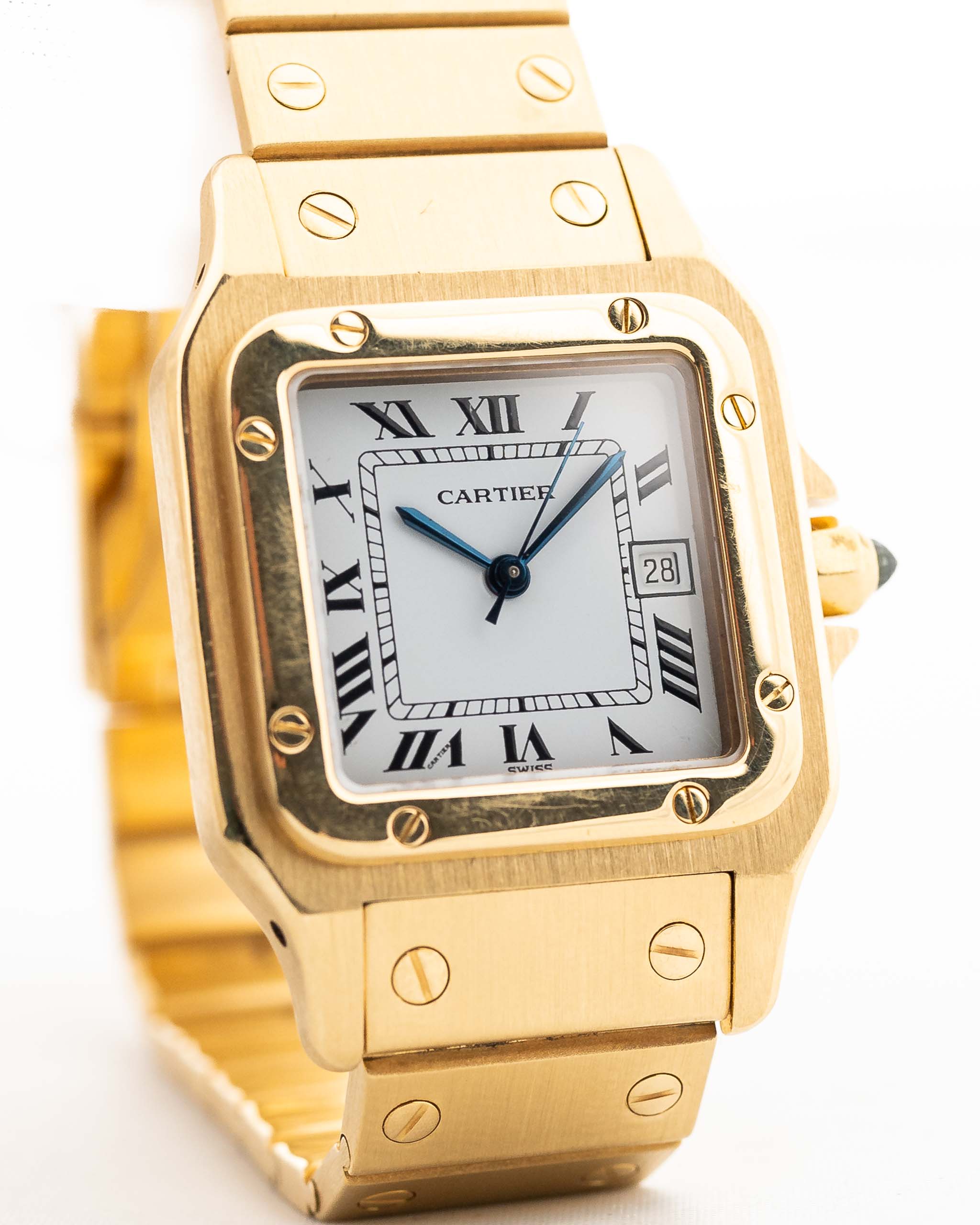 Foto de cerca de un Vintage Cartier Santos Carrée 2964 de la década de 1980. En Excelente estado, caja de 27mm en Oro Amarillo con movimiento Automático, esfera blanca Original y brazalete de Oro.