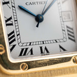 Foto de cerca de un Vintage Cartier Santos Carrée 2964 de la década de 1980. En Excelente estado, caja de 27mm en Oro Amarillo con movimiento Automático, esfera blanca Original y brazalete de Oro.