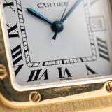 Foto de cerca de un Vintage Cartier Santos Carrée 2964 de la década de 1980. En Excelente estado, caja de 27mm en Oro Amarillo con movimiento Automático, esfera blanca Original y brazalete de Oro.