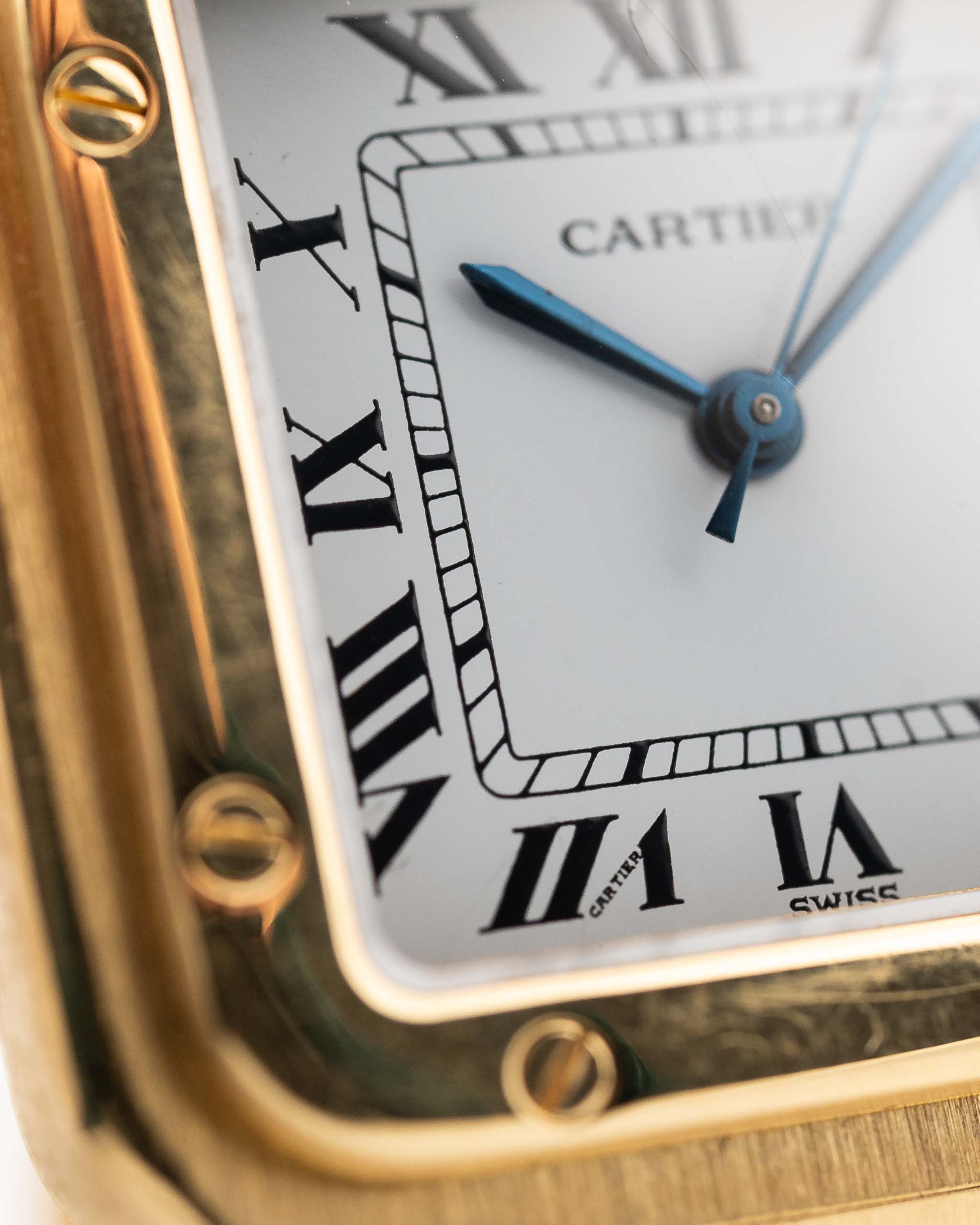 Foto de cerca de un Vintage Cartier Santos Carrée 2964 de la década de 1980. En Excelente estado, caja de 27mm en Oro Amarillo con movimiento Automático, esfera blanca Original y brazalete de Oro.