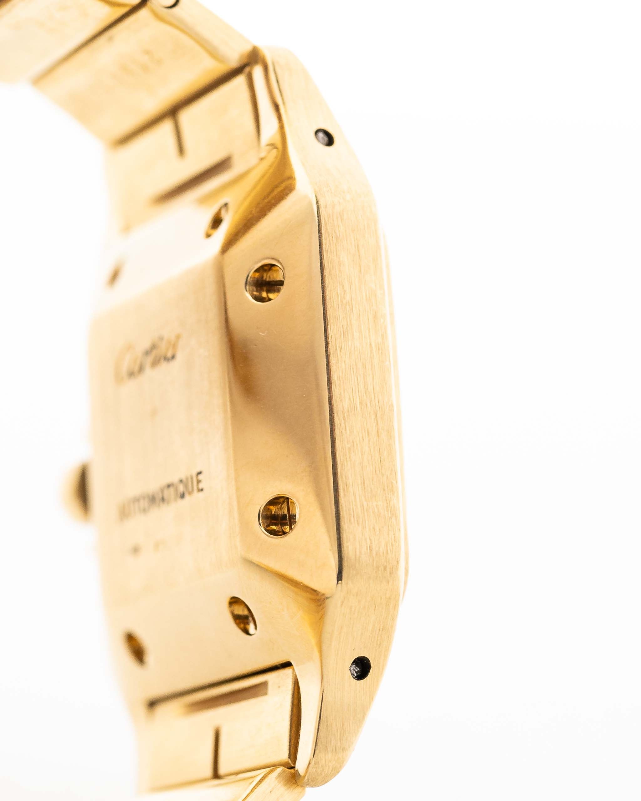 Foto de cerca de un Vintage Cartier Santos Carrée 2964 de la década de 1980. En Excelente estado, caja de 27mm en Oro Amarillo con movimiento Automático, esfera blanca Original y brazalete de Oro.
