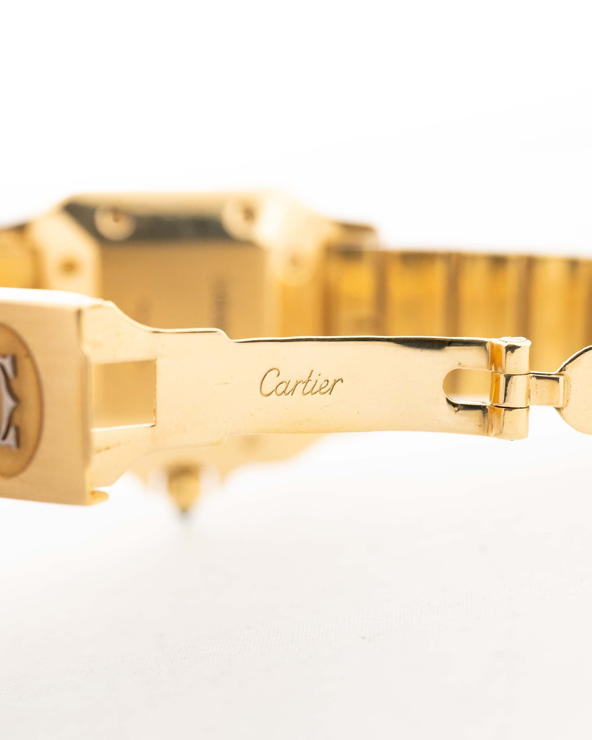 Foto de cerca de un Vintage Cartier Santos Carrée 2964 de la década de 1980. En Excelente estado, caja de 27mm en Oro Amarillo con movimiento Automático, esfera blanca Original y brazalete de Oro.