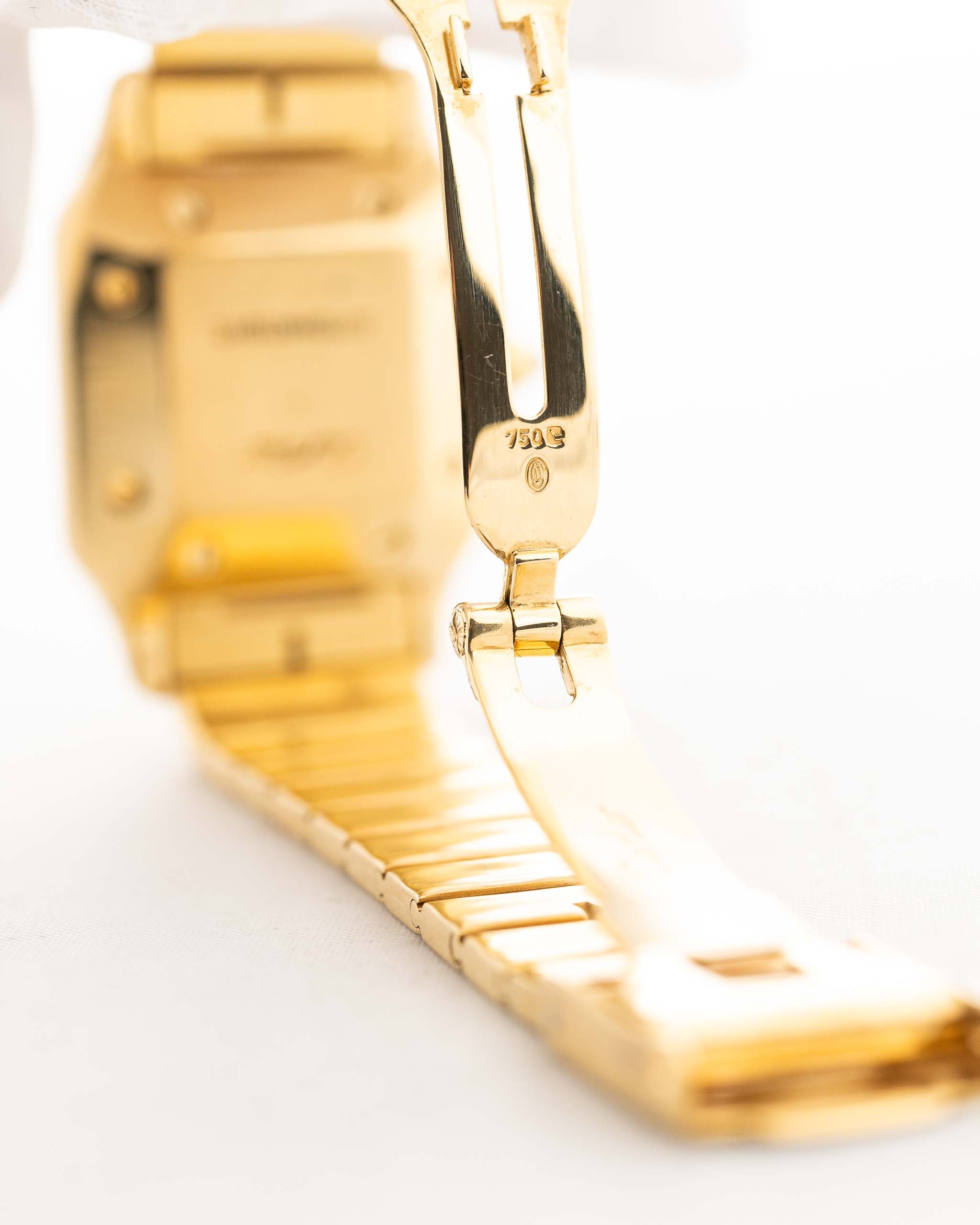 Foto de cerca de un Vintage Cartier Santos Carrée 2964 de la década de 1980. En Excelente estado, caja de 27mm en Oro Amarillo con movimiento Automático, esfera blanca Original y brazalete de Oro.