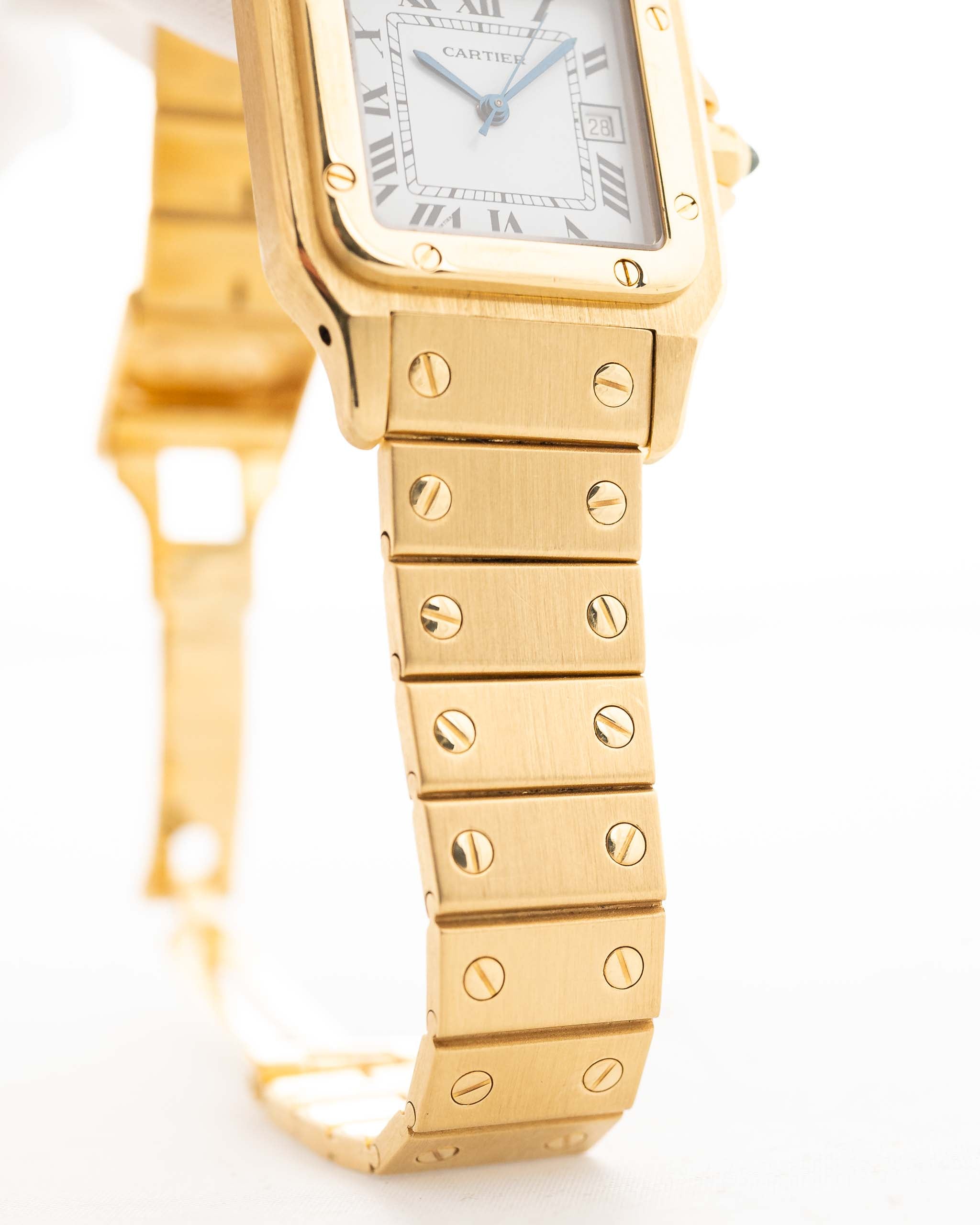 Foto de cerca de un Vintage Cartier Santos Carrée 2964 de la década de 1980. En Excelente estado, caja de 27mm en Oro Amarillo con movimiento Automático, esfera blanca Original y brazalete de Oro.
