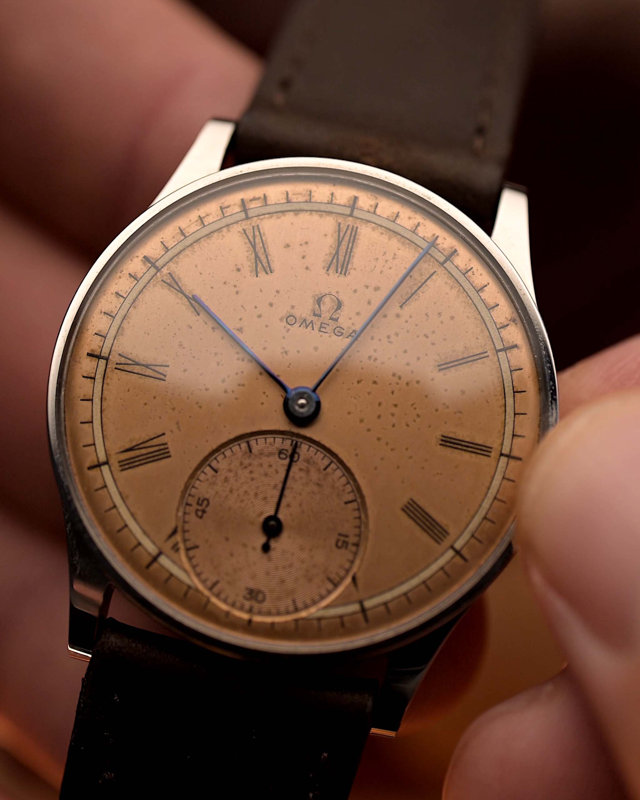 Vintage Omega Art Deco Roman Sub Second 1939 Reloj Antiguo en Acero sostenido por la mano de una persona