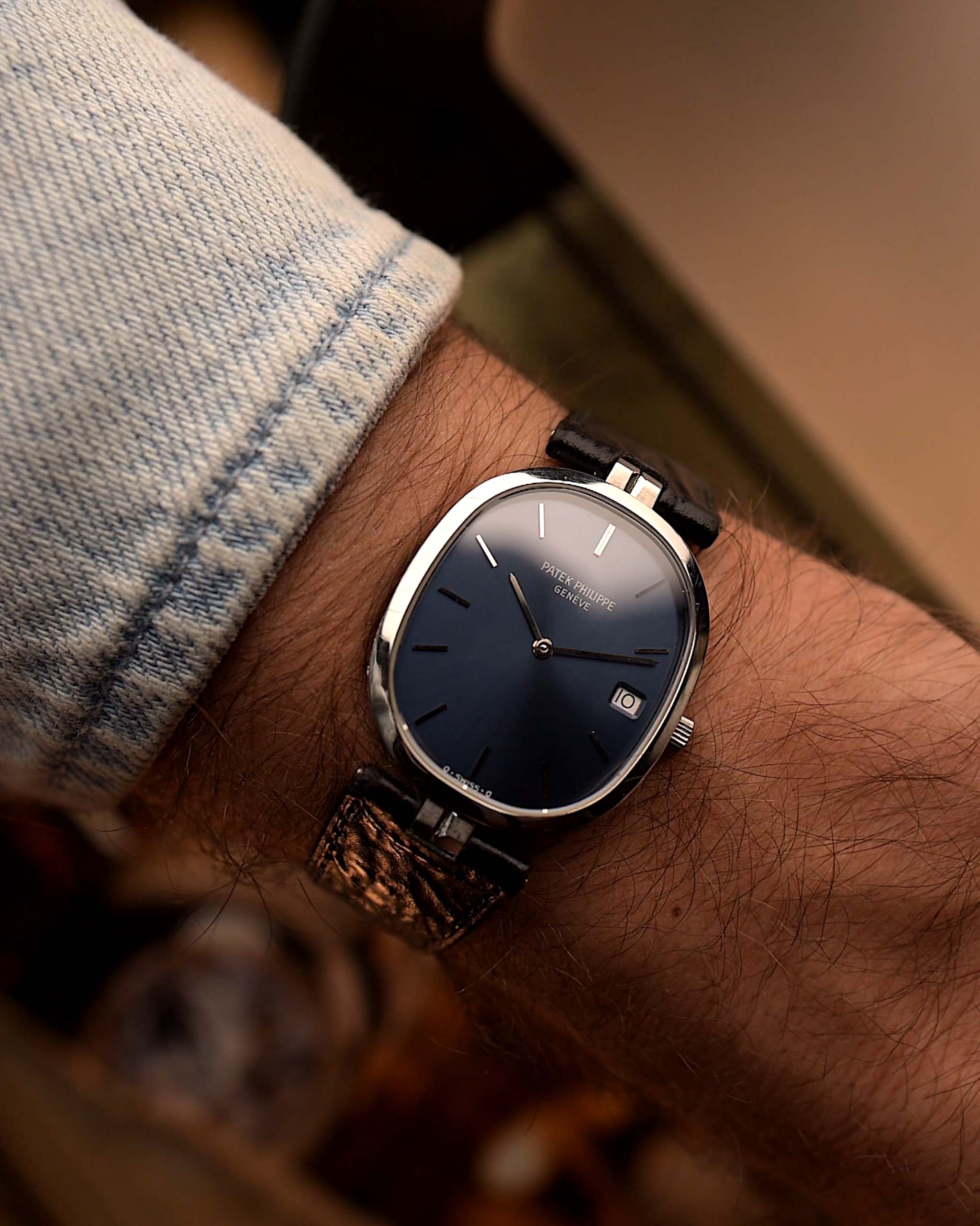 Reloj vintage Patek Philippe 3930 Ellipse, acero inoxidable, esfera azul con rayos de sol, caja en forma de elipse, movimiento de cuarzo, en la muñeca, fondo borroso