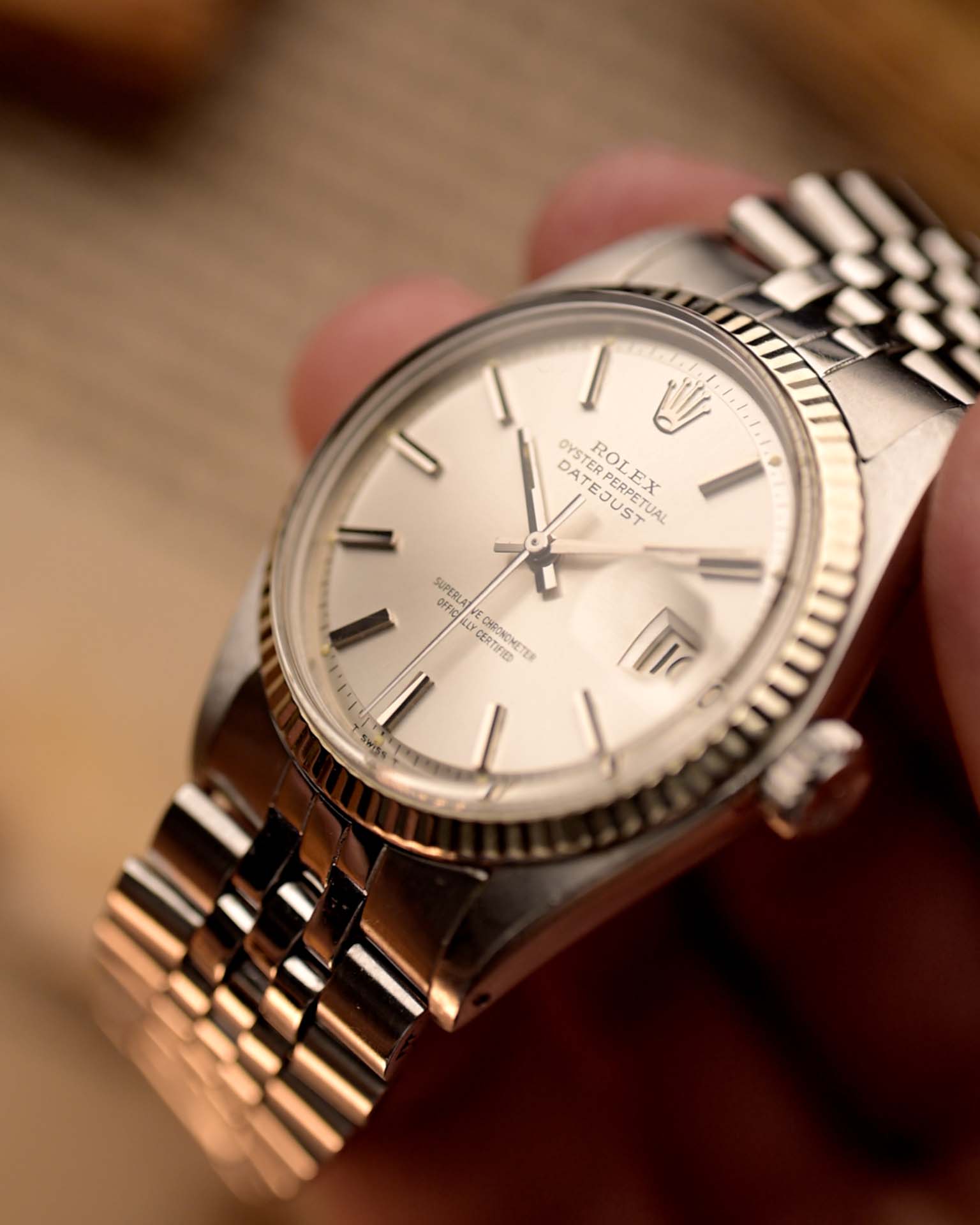 Primer plano de un reloj Rolex Datejust 1601 Vintage, esfera plateada con efecto sol, caja de acero inoxidable, movimiento automático, brazalete Jubilee, en la muñeca, fondo borroso