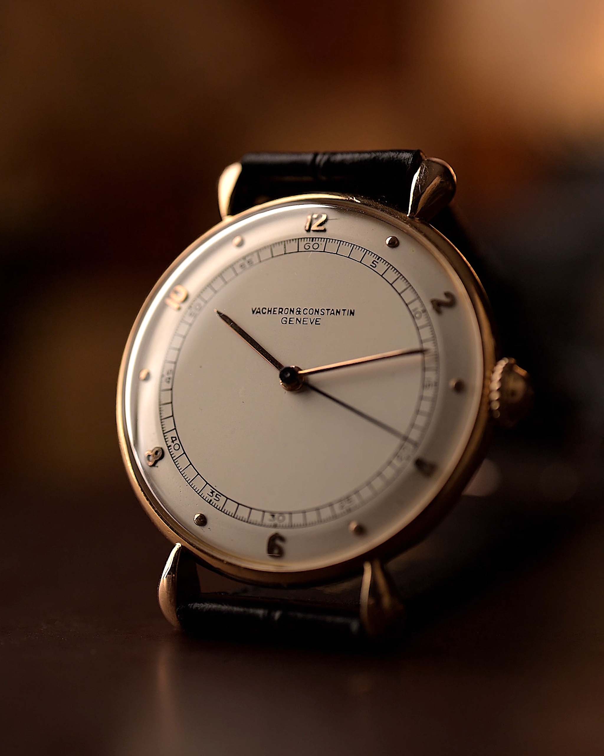 Primer plano de reloj Vintage Vacheron Constantin Teardrop de oro rosa de 18 quilates, esfera blanca-plateada, Cal. manual. V454, sobre correa negra, fondo borroso