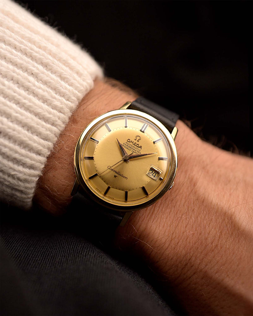 Reloj Vintage Omega Constellation 168004 Onyx 18k de 1963 en muñeca. 35,5 mm con caja de oro amarillo de 18 quilates, cronómetro automático Calibre 561, esfera dorada impecable y correa de piel.