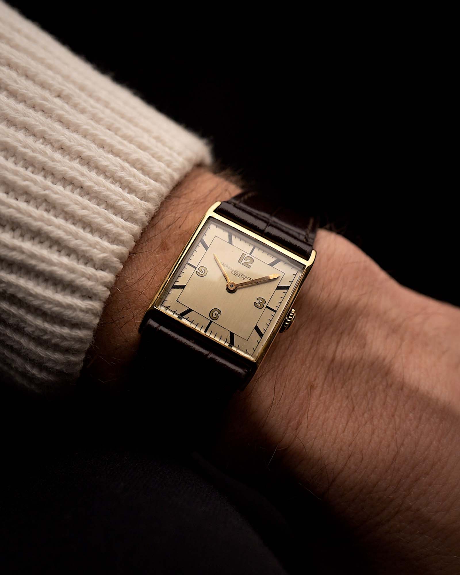 Reloj vintage Vacheron Constantin Square de 18 quilates en oro amarillo, esfera plateada, manual, correa de cuero marrón en una muñeca sobre fondo negro, vídeo.