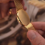 Close-ups of a Patek Philippe 3738 Ellipse Jumbo Vintage Watch from the 1980s on a blurred background. 31mm wide with 18k Yellow Gold Case, Automatic Caliber 240, Flawless Blue Sunburst Sigma Dial and Yellow Gold Bracelet.