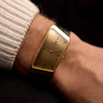 Vacheron Constantin 35202 Prestige de la France de los años 70 de pulsera sobre fondo negro. 32 mm de ancho con caja trapezoidal de oro amarillo de 18 quilates, calibre manual 1150/B, esfera dorada impecable y correa original de piel negra.