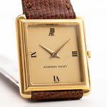 Vintage Audemars Piguet Square watch, 18k gold, golden satin dial, leather strap, white background