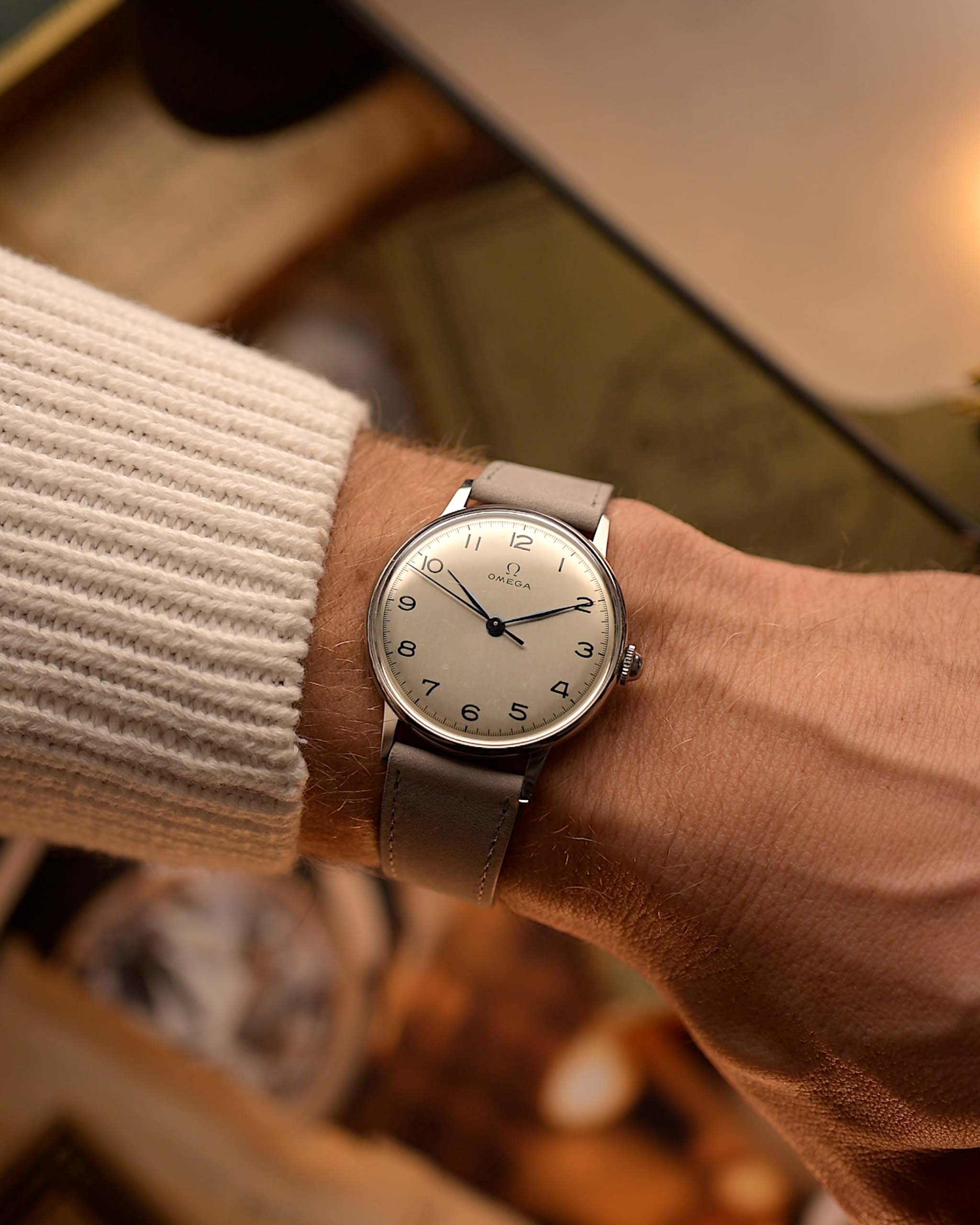 Montre Omega 2325 Jumbo Leaf vintage, cadran argenté, boîtier en acier inoxydable, mouvement à remontage manuel, bracelet en cuir gris, au poignet, fond flou