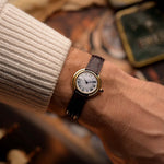 Montre Vintage Cartier Ellipse en or 18k, cadran blanc, signature Paris, bracelet original en cuir rouge, au poignet, fond flou
