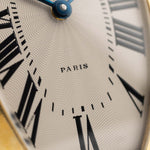 Photo en gros plan d'une Cartier Tonneau 18k Cadran Guilloché Paris des années 1980. 39mm avec boîtier en or jaune 18k, mouvement à remontage manuel, cadran Guilloché Paris original et bracelet en cuir noir.