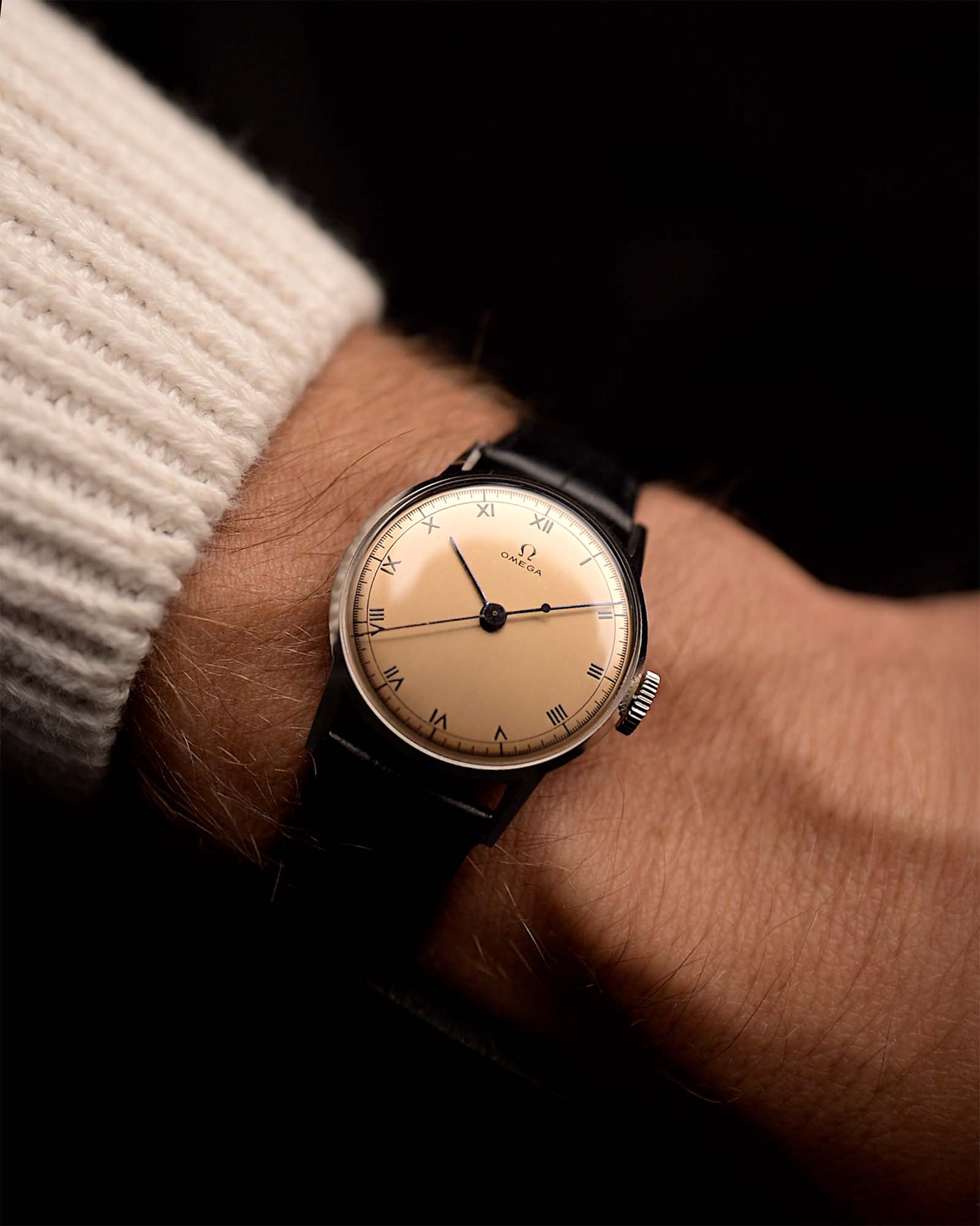 Montre Omega Medicus Salmon Roman de 1944 au poignet. 28 mm, acier inoxydable, calibre 23.4 SC à remontage manuel, cadran saumon impeccable, chiffres romains et bracelet en cuir noir.