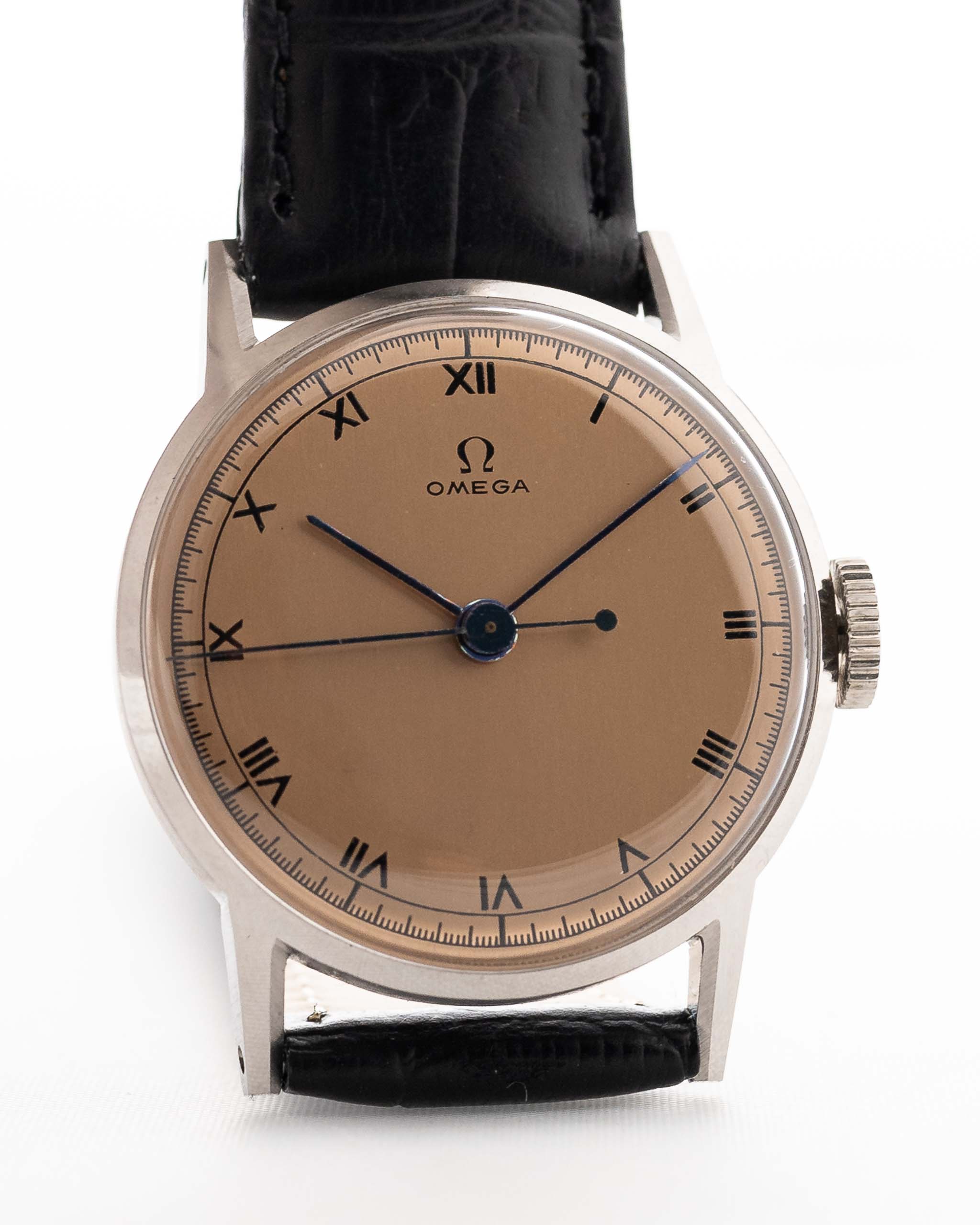 Montre Omega Medicus Salmon Roman de 1944. 28 mm, acier inoxydable, calibre 23.4 SC à remontage manuel, cadran saumon impeccable, chiffres romains et bracelet en cuir noir.