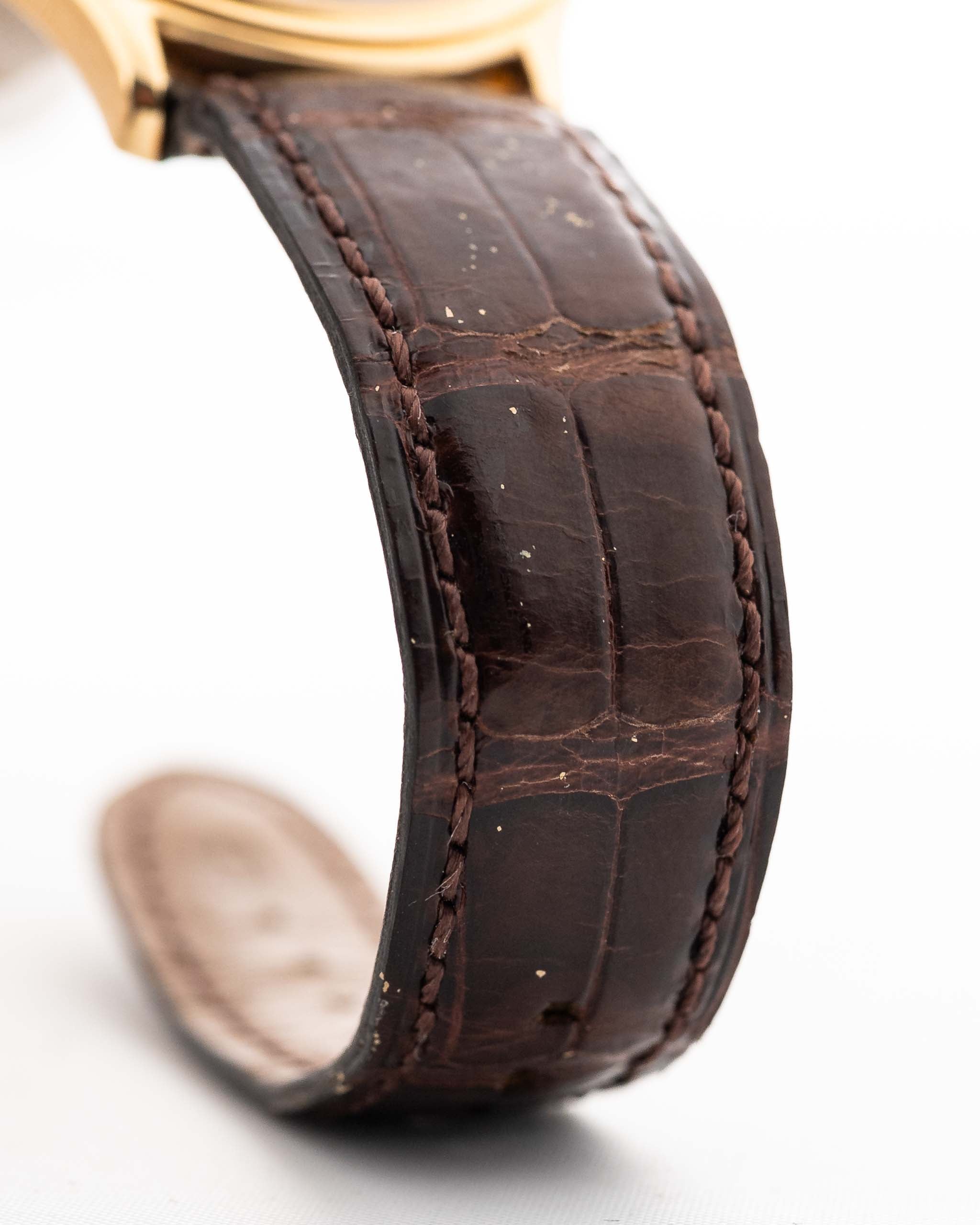 Gros plan sur un bracelet en cuir original de la Patek Philippe 3923 Calatrava datant des années 1990. 32mm en or jaune 18k avec mouvement manuel, cadran Sigma et boucle en or 18k.