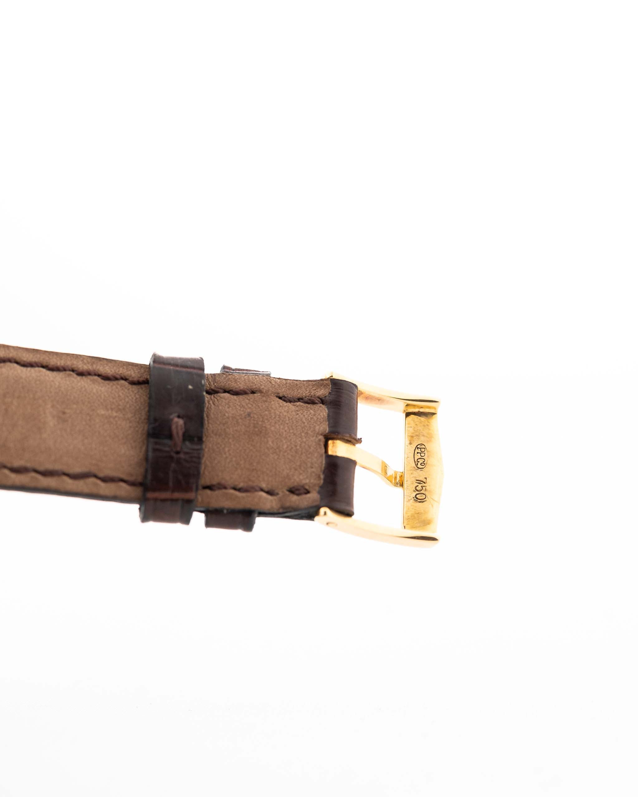Gros plan sur un bracelet en cuir original de la Patek Philippe 3923 Calatrava datant des années 1990. 32mm en or jaune 18k avec mouvement manuel, cadran Sigma et boucle en or 18k.