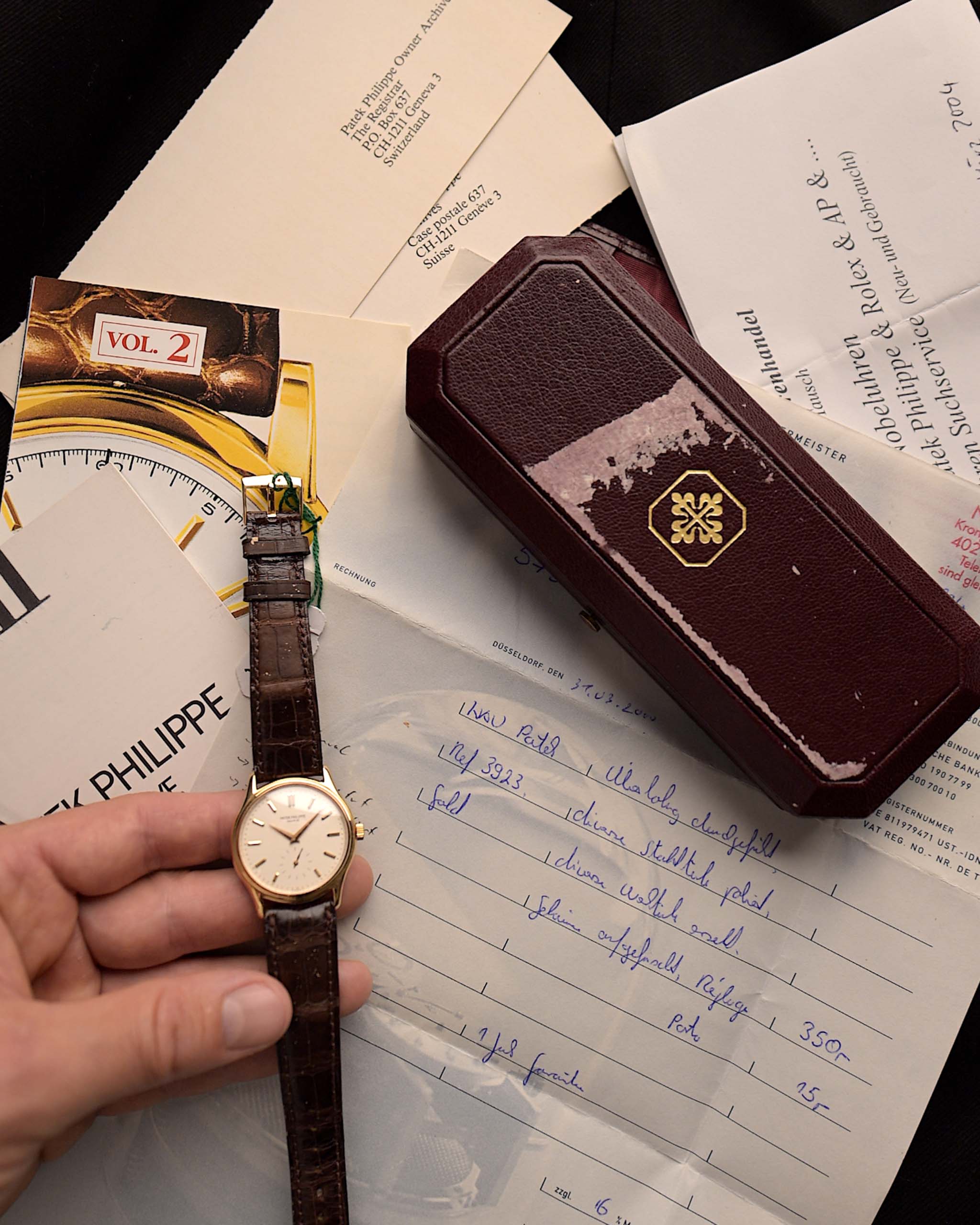 Gros plan sur la boîte et les papiers d'une Patek Philippe 3923 Calatrava des années 1990. 32mm en or jaune 18k avec mouvement à vent manuel, cadran Sigma et boucle en or 18k.