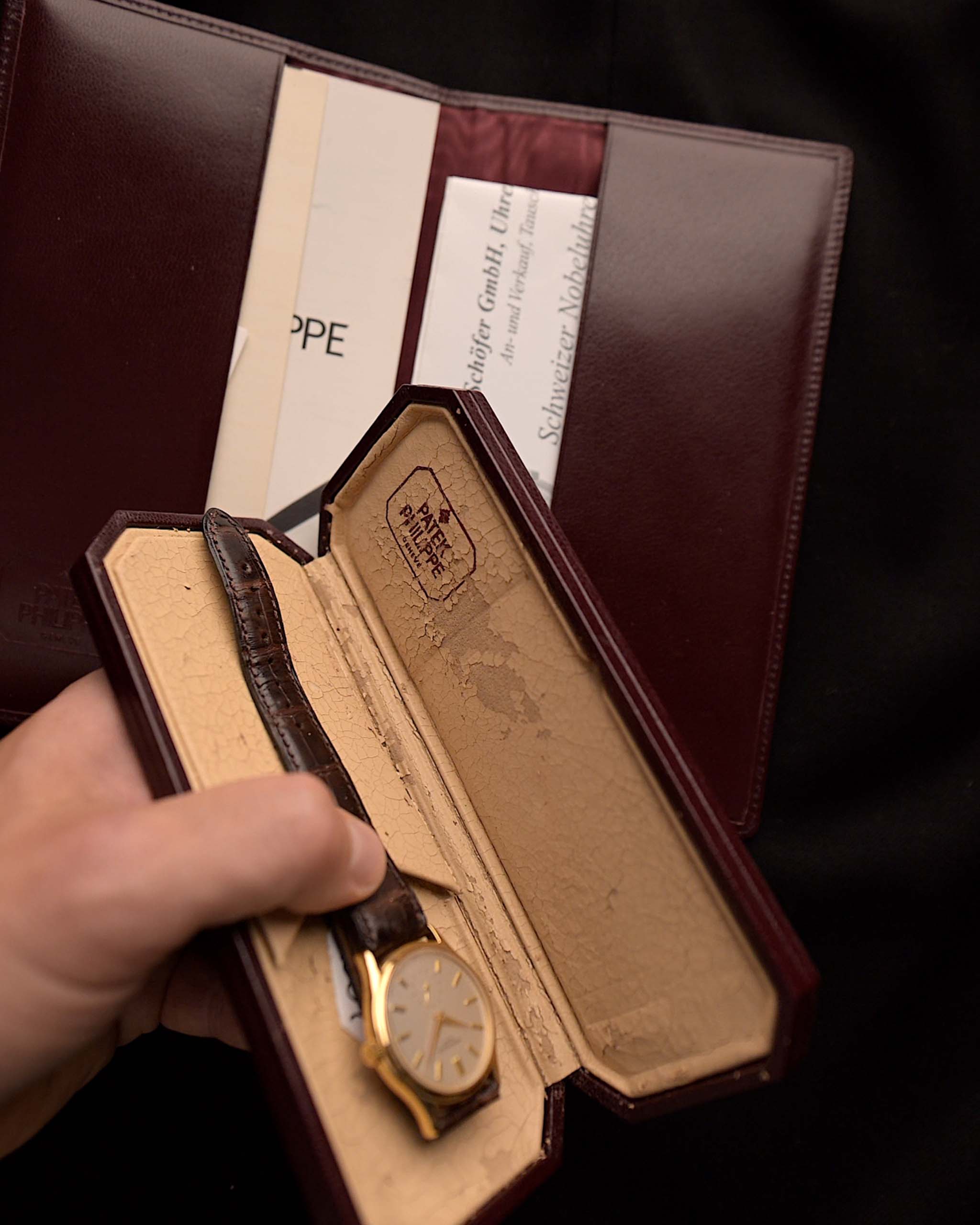 Gros plan sur la boîte et les papiers d'une Patek Philippe 3923 Calatrava des années 1990. 32mm en or jaune 18k avec mouvement à vent manuel, cadran Sigma et boucle en or 18k.