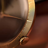 Gros plan sur le boîtier d'une montre Rolex Precision 9919 d'époque, en or 18 carats, cadran gris