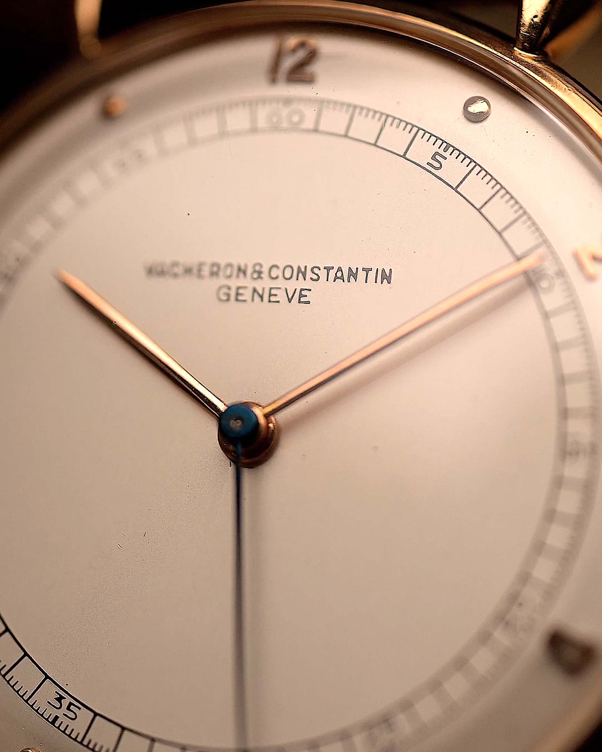 Gros plan sur le cadran de la montre Vintage Vacheron Constantin Teardrop en or rose 18 carats, cadran blanc-argenté, manuel Cal. V454, sur bracelet noir, fond flou