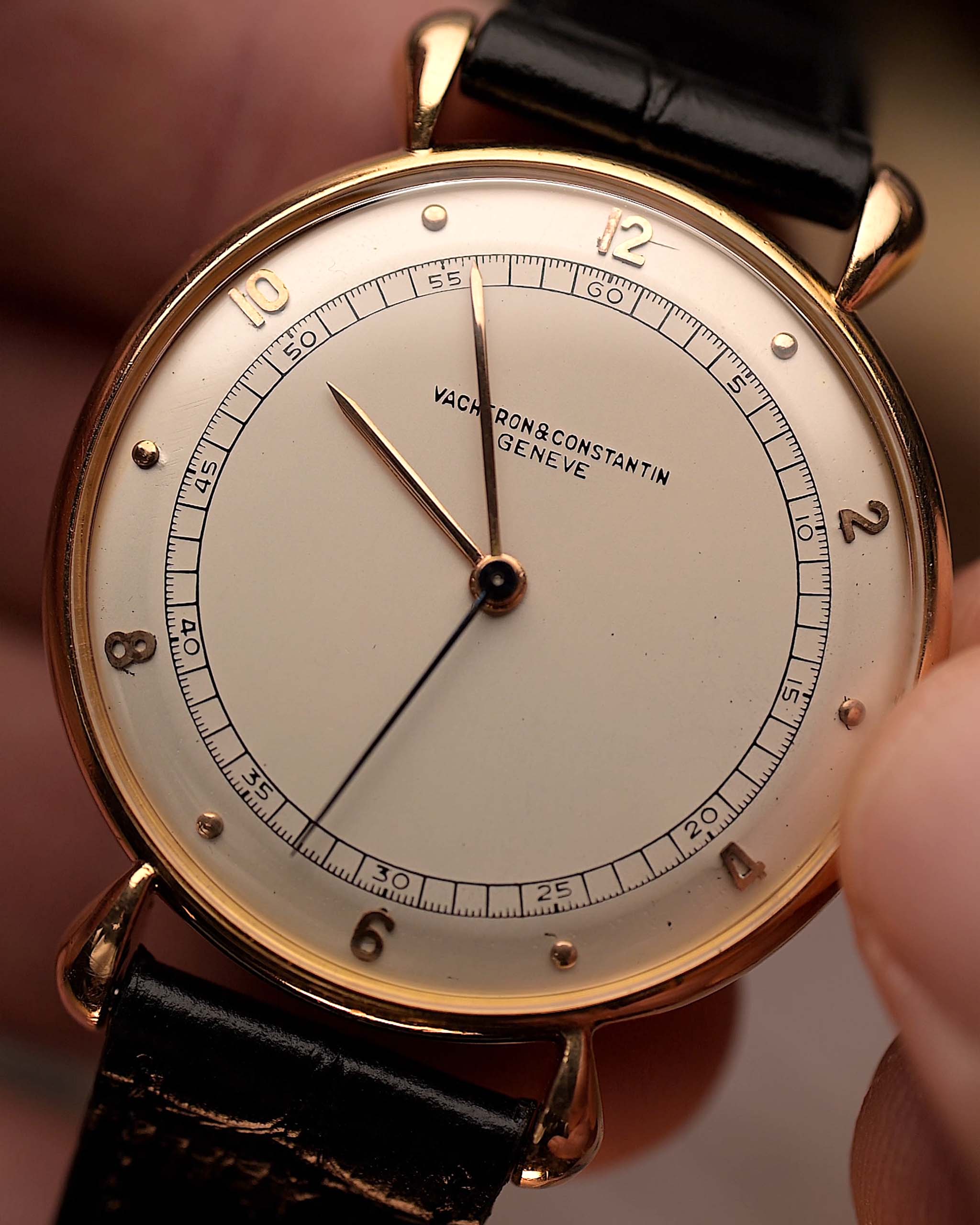 Gros plan sur la montre Vintage Vacheron Constantin Teardrop en or rose 18 carats, cadran blanc-argenté, manuelle Cal. V454, sur bracelet noir, fond flou