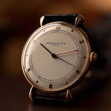 Gros plan sur la montre Vintage Vacheron Constantin Teardrop en or rose 18 carats, cadran blanc-argenté, manuelle Cal. V454, sur bracelet noir, fond flou