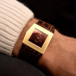 Montre vintage Rolex Cellini 4017 Midas Ruby Red des années 1970 sur un poignet. 28mm avec boîtier en or jaune 18k, mouvement à remontage manuel, cadran rouge rubis brillant et bracelet en cuir Rolex d'origine.