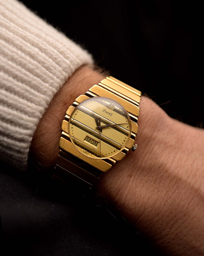 Montre Piaget Polo 15562 vintage, or 18 carats, cadran en or jaune, boîtier rond, mouvement à quartz, bracelet intégré en or, au poignet, fond noir, vidéo